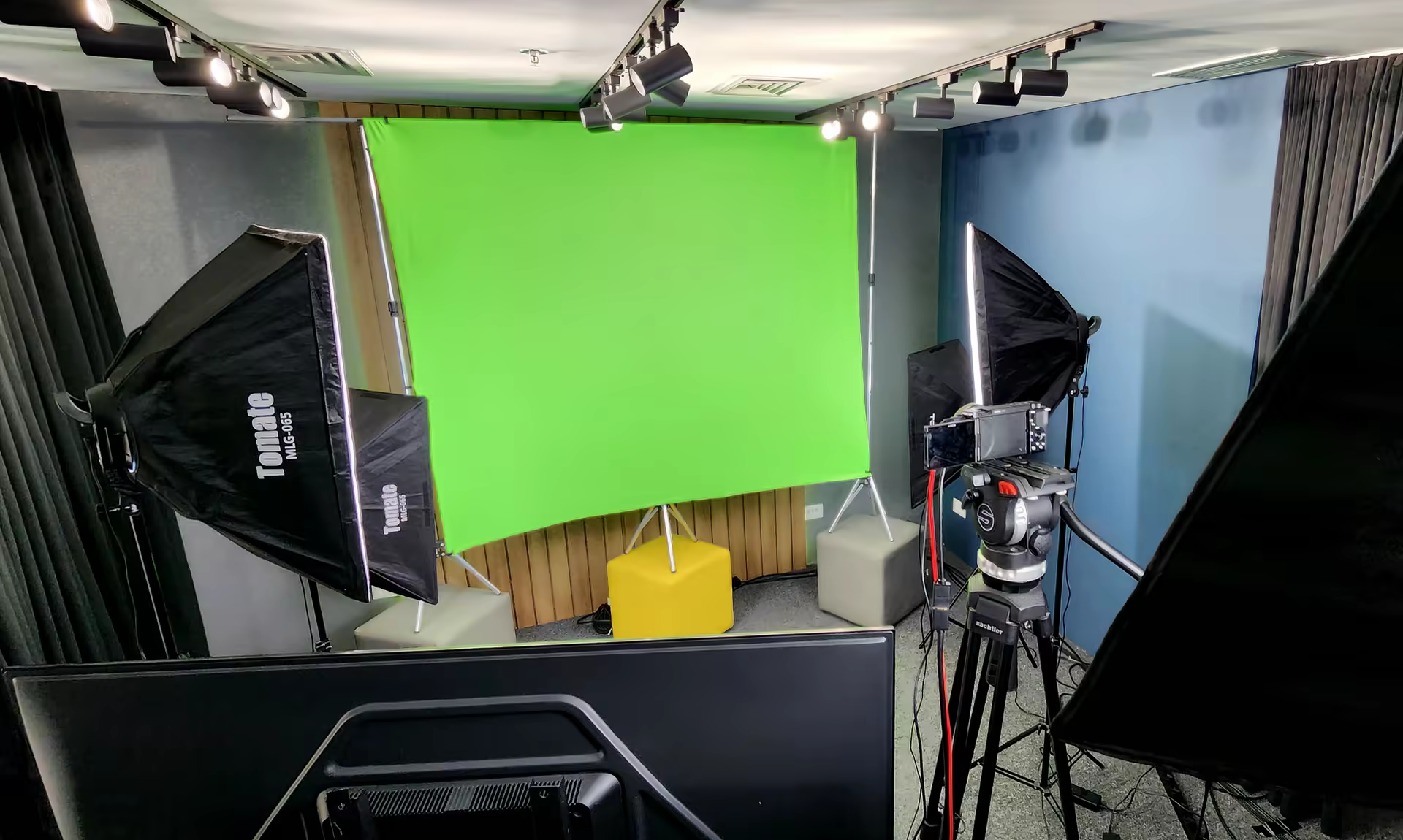 Fundo verde de chroma key montado no estúdio, com softboxes e câmera posicionada